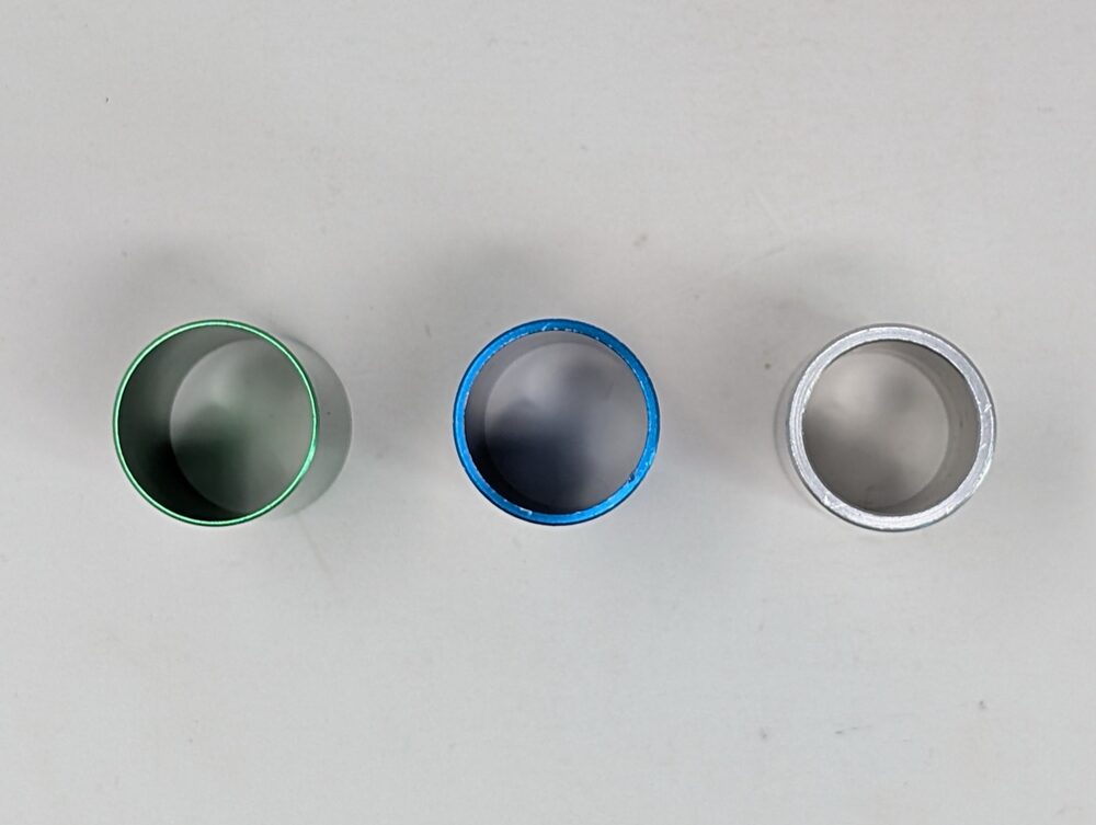 Green, blue, and silver inserts, bore-first — the difference in opening size is what actually changes chamber volume