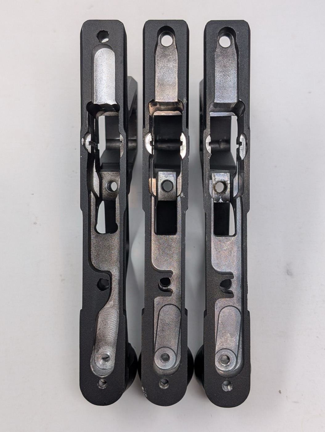 Internal steel frame, from above — identical shape and mounting holes across all three