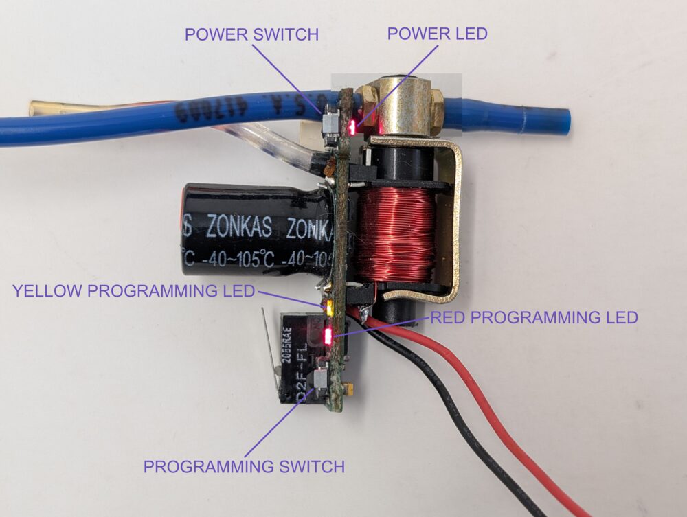 Power switch and programming switch, labeled, along with the power LED and both colors of the programming LED — the two switches are identical parts, opposite corners of the board