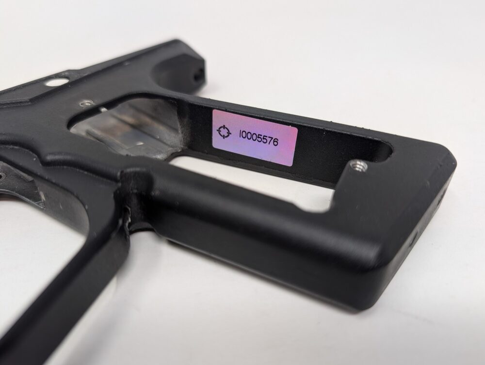XE grip frame serial sticker, visible through the grip cutout with the grips open