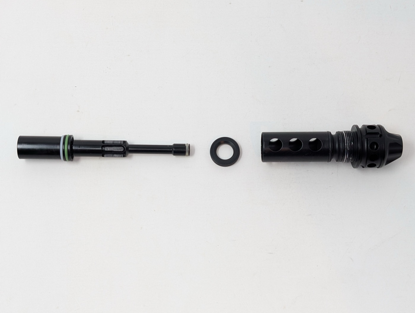 Bolt, bolt stop, and bolt sleeve laid out left to right, front to rear — same orientation as the marker itself